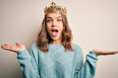 Soyutlanmış arka planda kraliçe altın tacını takan genç sarışın kız çılgın ve başarıyı kollarını kaldırıp heyecanla haykırarak kutluyor. Kazanan konsept