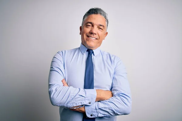 Middle age handsome grey-haired business man wearing elegant shirt and tie happy face smiling with crossed arms looking at the camera. Positive person.