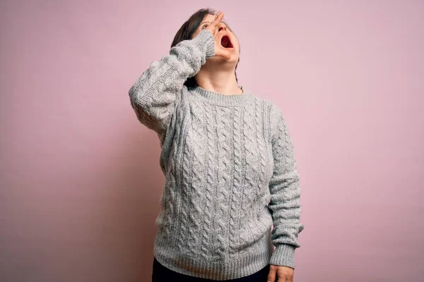 若いダウン症候群の女性が孤立した背景の叫びにカジュアルなセーターを着て 口の中で手で横に大声で叫んでいます コミュニケーションの概念 — ストック写真