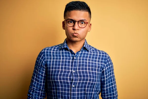 Mladý Pohledný Latinskoamerický Muž Neformální Košili Brýlích Žlutém Pozadí Nafoukané — Stock fotografie