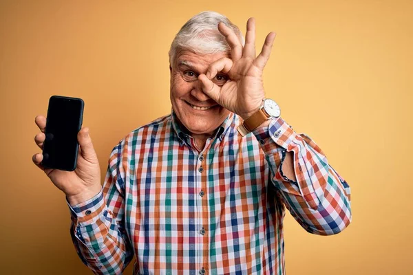 Ältere Gutaussehende Mann Mit Smartphone Zeigt Bildschirm Über Gelbem Hintergrund — Stockfoto