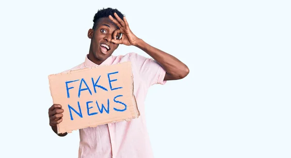 Ung Afrikansk Amerikan Man Håller Falska Nyheter Banner Ler Glad — Stockfoto