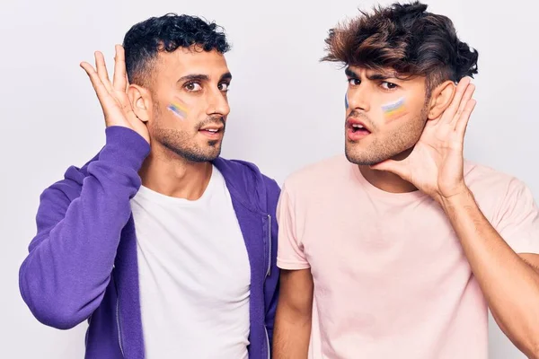 Unga Homosexuella Par Ritar Regnbågsflagga Ansiktet Och Ler Med Handen — Stockfoto