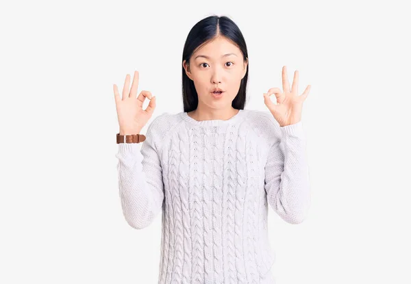 스웨터를 아름다운 여자가 표정으로 충격을 손가락으로 승인의 상징을 있습니다 — 스톡 사진