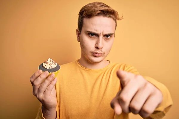 Young Handsome Redhead Man Eating Sweet Chocolate Cupcake Dessert Yellow — Stock Photo, Image