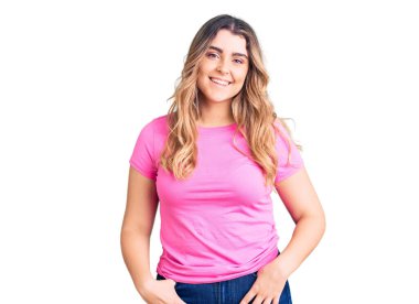 Yüzünde mutlu ve havalı bir gülümsemeyle spor giysisi giyen beyaz bir kadın. şanslı kişi. 