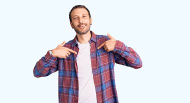 Gündelik kıyafetler giyen, kendine güveni olan, kendini gururlu ve mutlu gösteren genç yakışıklı bir adam.. 