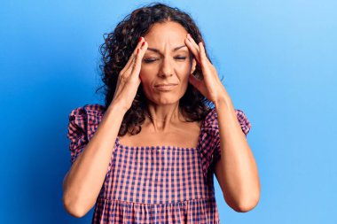 Orta yaşlı, güzel bir kadın. Elleri kafasında rahat bir tişört giyiyor. Stres yüzünden baş ağrısı çekiyor. migren ağrısı. 