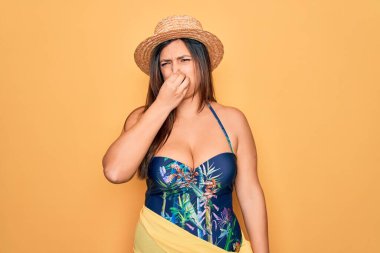 Sarı arka planda, İspanyol şapkalı ve mayo giyen genç bir kadın pis ve iğrenç bir koku alıyor. Dayanılmaz bir koku. Parmakları burnunda nefesini tutuyor. Kötü kokuyor.