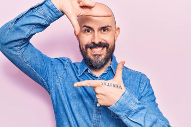 Gündelik kıyafetler giyen, gülümseyen, elleri ve parmakları gülen yüzlü genç yakışıklı bir adam. yaratıcılık ve fotoğrafçılık kavramı. 