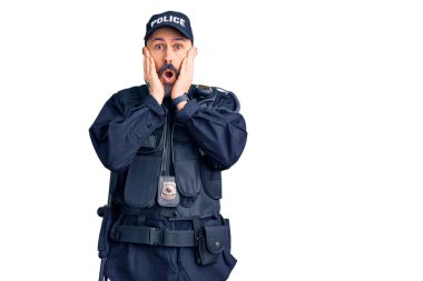 Polis üniforması giyen genç ve yakışıklı bir adam. Korkmuş ve şok olmuş, şaşırmış ve hayrete düşmüş. 