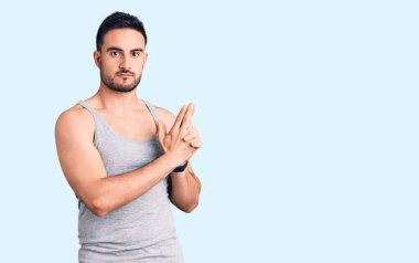 Mayo giyen genç yakışıklı adam ellerinin birarada dua ederek af diliyor kendinden emin bir şekilde gülümsüyor.. 