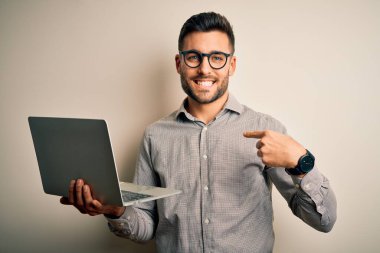 Gözlüklü genç iş adamı bilgisayar bilgisayarı kullanarak kendini işaret ederek çalışıyor.