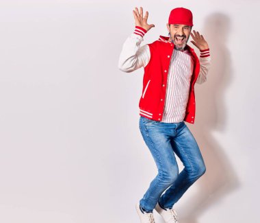 Beyzbol üniforması giyen orta yaşlı yakışıklı adam mutlu gülümsüyor. İzole edilmiş beyaz arka planda yüzünde gülümsemeyle zıpla