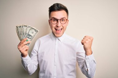 Yakışıklı beyaz iş adamı elinde bir tomar banknotla gururla bağırıyor zaferi ve başarıyı kutluyor çok heyecanlı, coşkulu duyguları alkışlıyor.