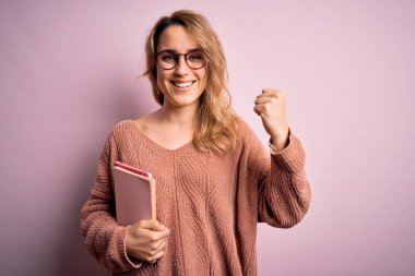 Pembe arka planda gözlük takan güzel sarışın kadın gururla bağırıyor ve zaferi kutluyor. Çok heyecanlı, coşkulu bir duygu.