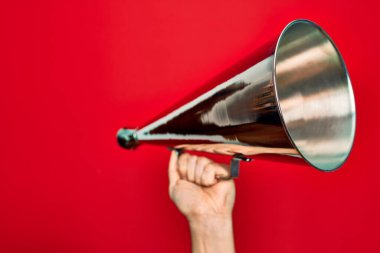 İnzivaya çekilmiş kırmızı arka planda klasik megafonu tutan adamın güzel eli.