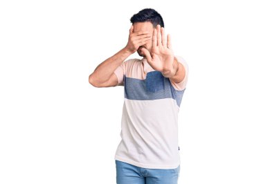 Mayo giyen genç yakışıklı adam ellerinin birarada dua ederek af diliyor kendinden emin bir şekilde gülümsüyor.. 