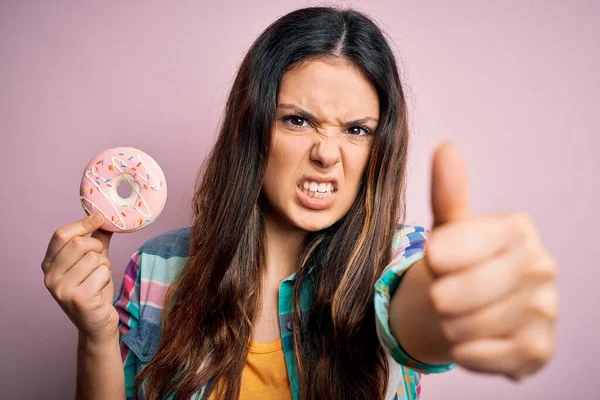 Joven Hermosa Morena Comiendo Donut Rosa Dulce Sobre Fondo Aislado —  Fotos de Stock