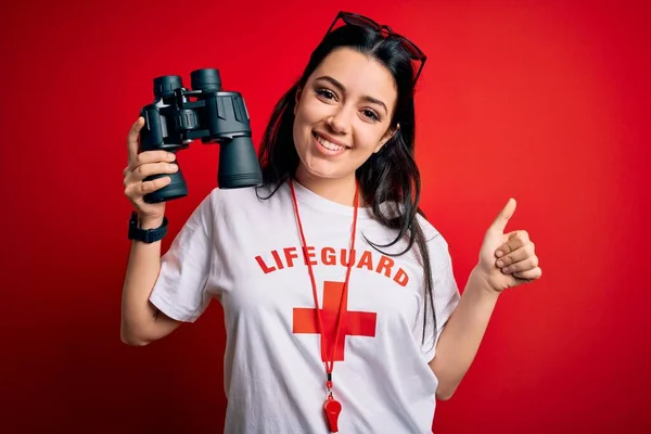 Junge Rettungsschwimmerin Schutzausrüstung Mit Fernglas Über Rotem Hintergrund Glücklich Mit — Stockfoto