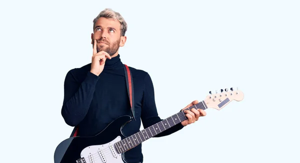 Young Handsome Blond Man Playing Electric Guitar Serious Face Thinking — Stock Photo, Image
