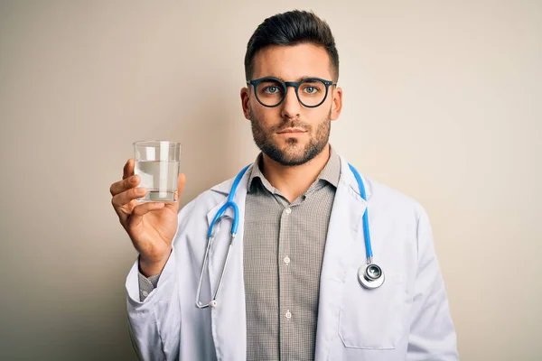 Młody Lekarz Noszący Stetoskop Pijący Świeżą Szklankę Wody Odizolowanym Tle — Zdjęcie stockowe