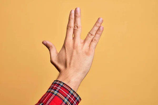 考卡族年轻人的手在孤立的黄色背景下伸出指尖 向瓦肯致敬 向后伸出手指头 表现出怪异的文化 — 图库照片