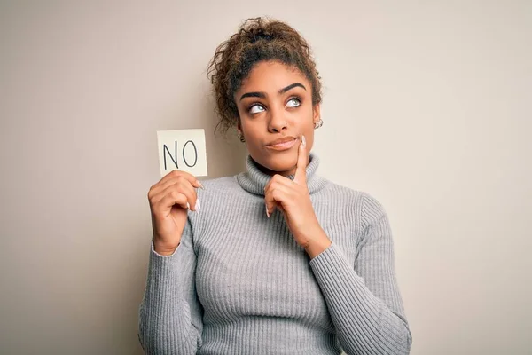 アフリカ系アメリカ人の少女がメモ用紙を持っている質問について真剣に考えている言葉の否定的なメッセージがない非常に混乱したアイデア — ストック写真