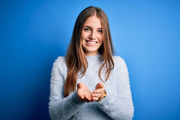Młoda Piękna Ruda Kobieta Ubrana Luźny Sweter Odizolowanym Niebieskim Tle — Zdjęcie stockowe