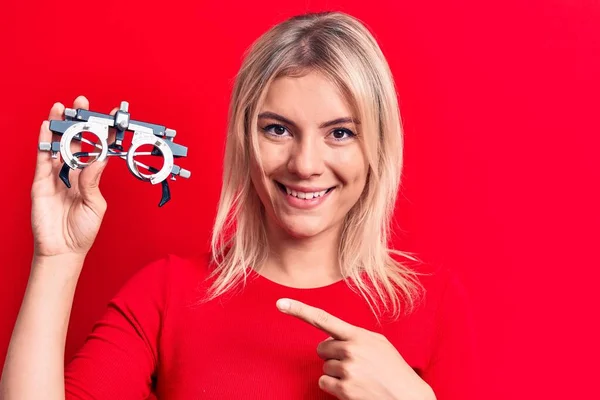 Jong Mooi Blond Vrouw Holding Optometrie Bril Geïsoleerde Rood Achtergrond — Stockfoto