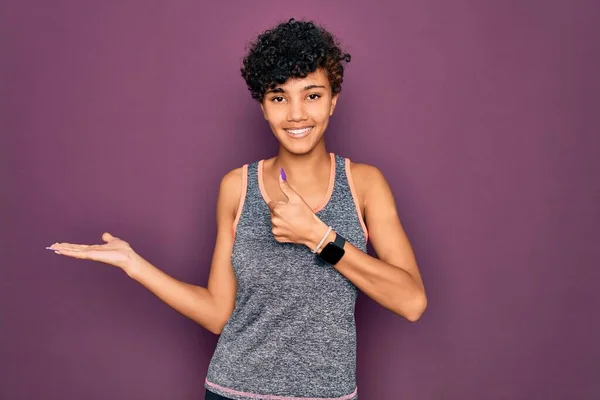 若い美しいアフリカ系アメリカ人のアフロスポーツ女性がスポーツウェアを着て運動をする手のひらの手を表示し 親指でOkジェスチャーを行う 笑顔幸せと陽気な — ストック写真