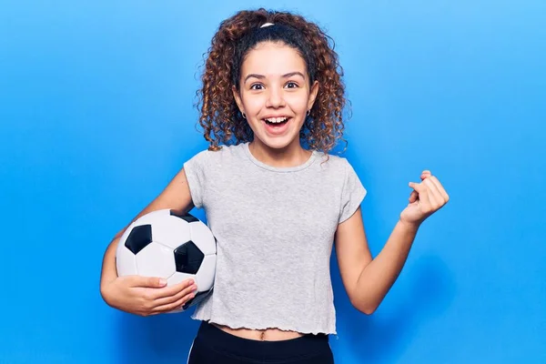 Menina Bonita Com Cabelo Encaracolado Segurando Bola Futebol Gritando Orgulhoso — Fotografia de Stock