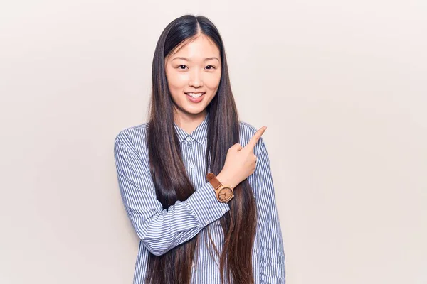 Молодая Красивая Китаянка Повседневной Полосатой Рубашке Улыбается Весело Указывая Рукой — стоковое фото
