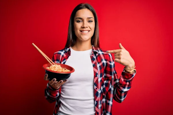 Joven Hermosa Morena Comiendo Fideos Usando Palillos Sobre Fondo Rojo —  Fotos de Stock