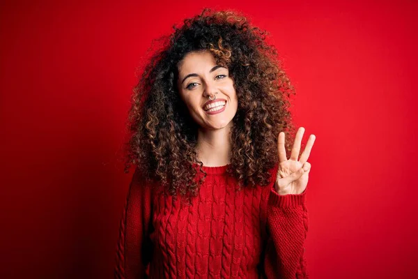 곱슬머리에 피어싱을 예쁘고 곱슬곱슬 스웨터를 여성은 자신감 행복하게 웃으면서 손가락으로 — 스톡 사진