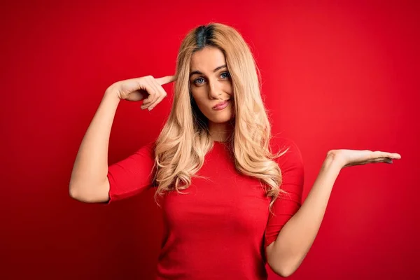 Jovem Mulher Loira Bonita Vestindo Camiseta Casual Sobre Fundo Vermelho — Fotografia de Stock