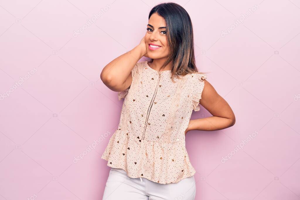 Young beautiful brunette woman wearing casual clothes smiling happy and confident. Standing with smile on face over isolated pink background