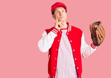 Beyzbol üniforması giyen yakışıklı bir genç, elinde Golve ve topuyla ciddi bir yüzle eli çenesinde soru soran, kafa karıştırıcı bir fikir hakkında düşünceli. 