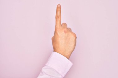 İzole edilmiş pembe arka planda parmaklarını gösteren beyaz bir gencin eli işaret parmağı kullanarak bir numarayı sayıyor, fikir ve anlayış gösteriyor.