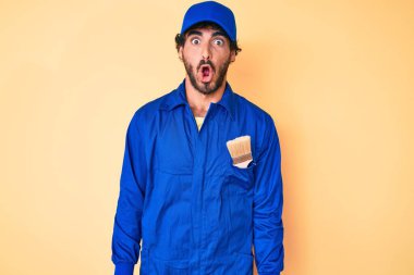 Kıvırcık saçlı ve ayı gibi giyinmiş yakışıklı genç adam. Üniforma giymiş.. 