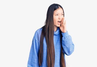 Balıkçı yaka kazak giyen genç, güzel bir Çinli kadın el ele verip bağırıyor. iletişim konsepti. 