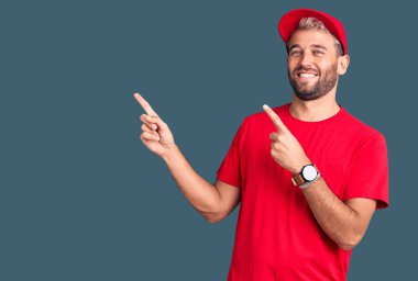 Tişört giyen, şapkalı, gülümseyen ve kameraya bakan yakışıklı sarışın bir adam.. 