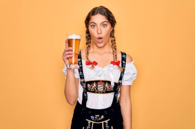 Güzel, sarışın, mavi gözlü, Ekim Festivali elbisesi giyen, bir bardak bira içen, şaşırmış ve korku ifadesinden korkan Alman bir kadın.