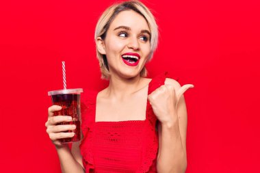 Genç, güzel, sarışın bir kadın bir bardak kola içti. Parmağını kaldırdı ve gülümsedi. Ağzını açtı. 