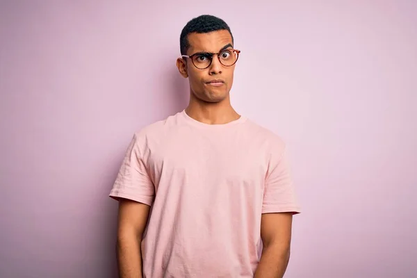 Pohledný Afroameričan Neformálním Tričku Brýlích Růžovém Pozadí Skeptický Nervózní Zamračený — Stock fotografie