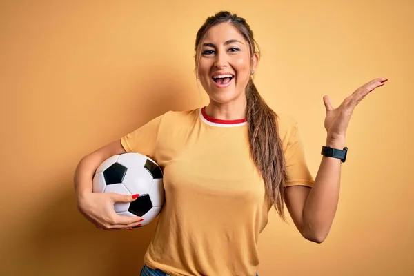 Güzel Esmer Kadın Futbol Oynuyor Futbol Topunu Sarı Arka Planda — Stok fotoğraf