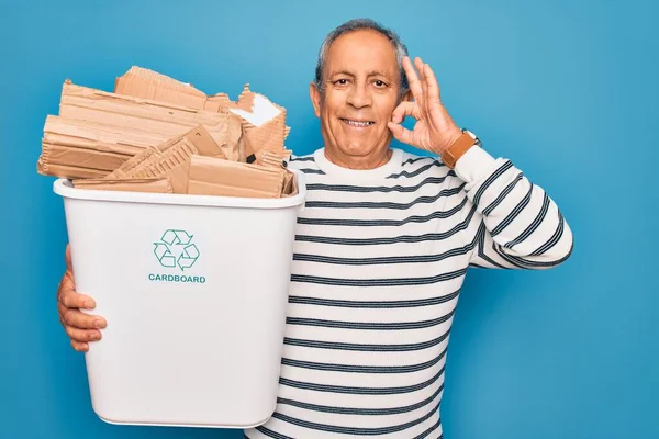 廃棄物を保持している高齢者のリサイクルは 指でOkサインを行う青の背景にリサイクルすることができます 優れたシンボル — ストック写真