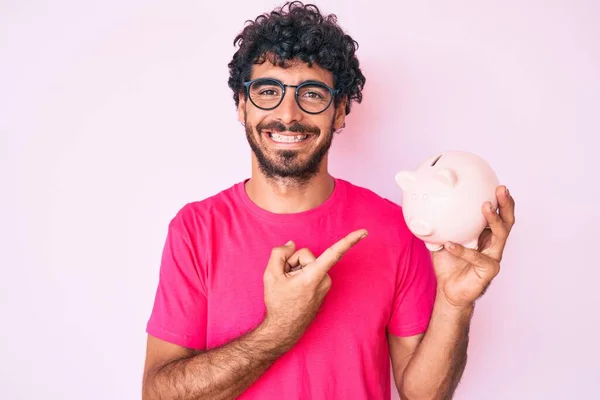 Bonito Jovem Com Cabelo Encaracolado Urso Segurando Porquinho Banco Sorrindo — Fotografia de Stock