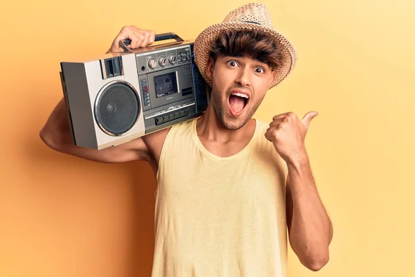 Young Hispanic Man Holding Boombox Listening Music Pointing Thumb Side — Stock Photo, Image