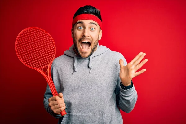 Junger Gutaussehender Sportler Mit Tennisschläger Sportbekleidung Vor Rotem Hintergrund Sehr — Stockfoto
